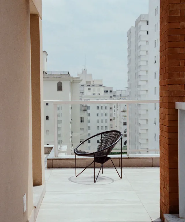 Balcón luminoso con una silla de diseño y vistas a la ciudad